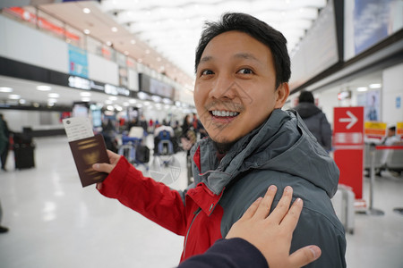 快乐的候机时手抚亚洲肩在机场迎接朋友手拿大行李护照旅客和友好的概念有趣亚洲人震惊高清图片素材