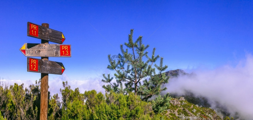 马德拉岛岩石山脉的登活动皮科鲁伊沃最高点的指路标志飞过云层步行瑞沃惊人的图片