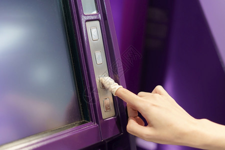 金融的妇女佩戴橡皮手指按自动取款机按钮银行业服务图片