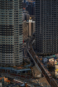 运输日本东京市景摩天大楼的顶端或空中视图火车在晚上高楼交通和勤Asiia旅行和游概念之间的铁路轨迹上运行在日本城市亚洲人户外高清图片素材
