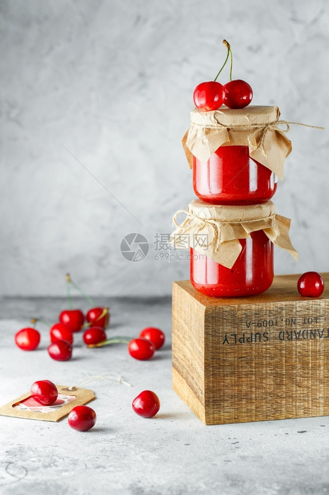 荒野新鲜圣诞节在灰色背景的木盒子上玻璃罐里装着自制樱桃果酱两罐放在木头上樱桃酱在背面食品摄影季节烹饪概念图片