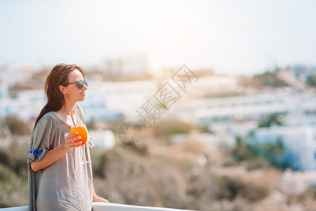 休息奢华采取女人在希腊小镇的美丽景色中放松女人在豪华酒店度假村放松享受完美的暑假米科诺斯高清图片素材