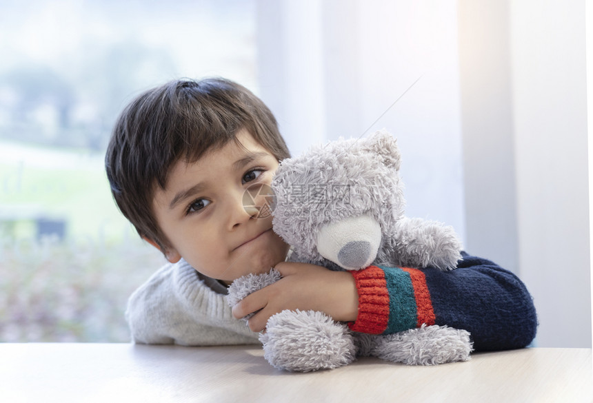 可爱的小男孩抱着泰迪熊图片