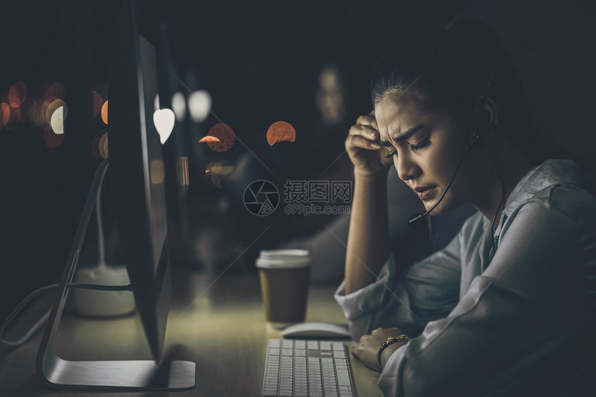操作员顾客亚洲女商人在办公室客户服务和呼叫中心部门硬工和加班压力头痛低光环境等技术计算机上工作到很晚而且工作时间也非常晚以及沮丧图片