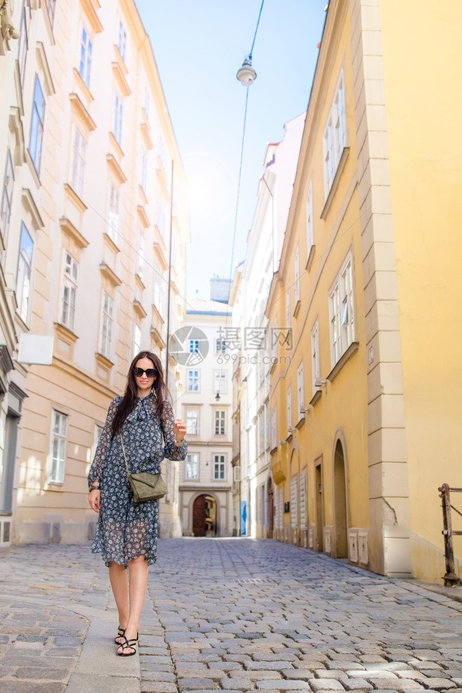 快乐的女子在欧佩安街上行走年轻有吸引力的游客维也纳市外游览者维也纳市外在大街上莫扎特女人在城市里行走莫扎特女人在城市里行走女孩冬图片
