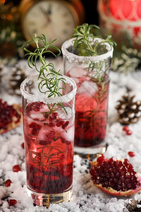 季节冲床玻璃杯和石榴玛格丽塔与罐头红莓迷迭香完美鸡尾酒为圣诞派对补品图片