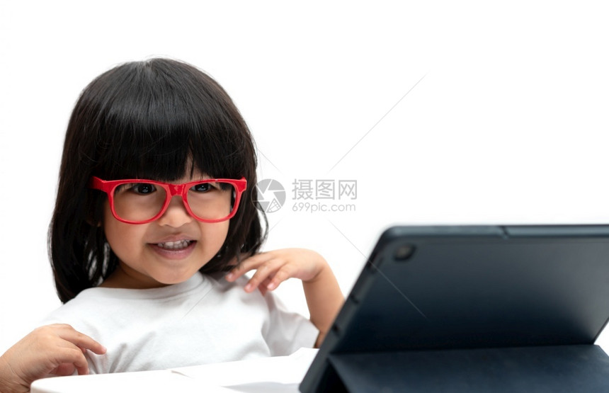 距离红色的学校小亚洲龄前女孩穿着红眼镜白背景使用平板电脑亚洲女孩聊天和学习用视频电话与平板脑为学童提供教育概念进行视频电话学习图片