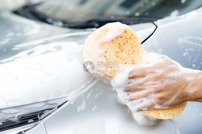 灰色的持有手黄海绵和泡沫清洗窗的工人男子手持黄海绵和泡沫洗车用擦玻璃窗户门蜡图片