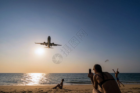 日落船泰国PHUKET泰国PHUKETFEB52018年未定义旅行者在泰国2018年月5日的布吉国际机场附近海滨距离降落的飞机上背景图片