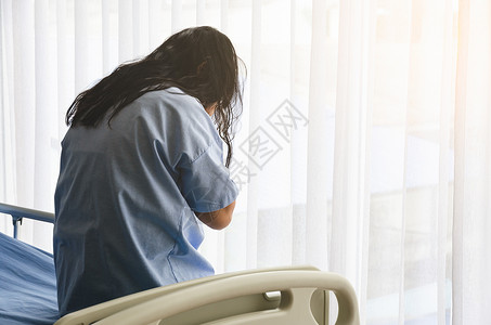 医疗的人们窗户躺在床上的亚裔女病人背影中她对自己的疾病表示悲伤并亲手面对健康保险概念痛高清图片素材