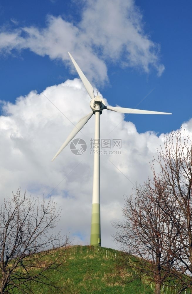 旋转塔绿色山上作为替代能源的风力涡轮机与前面有灌木和栅栏的蓝云天空相对创新图片