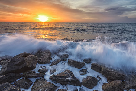 追波风太阳礁在黑海岩石岸线上景与多彩的日出天空和美丽波浪交织在一起早晨海浪背景