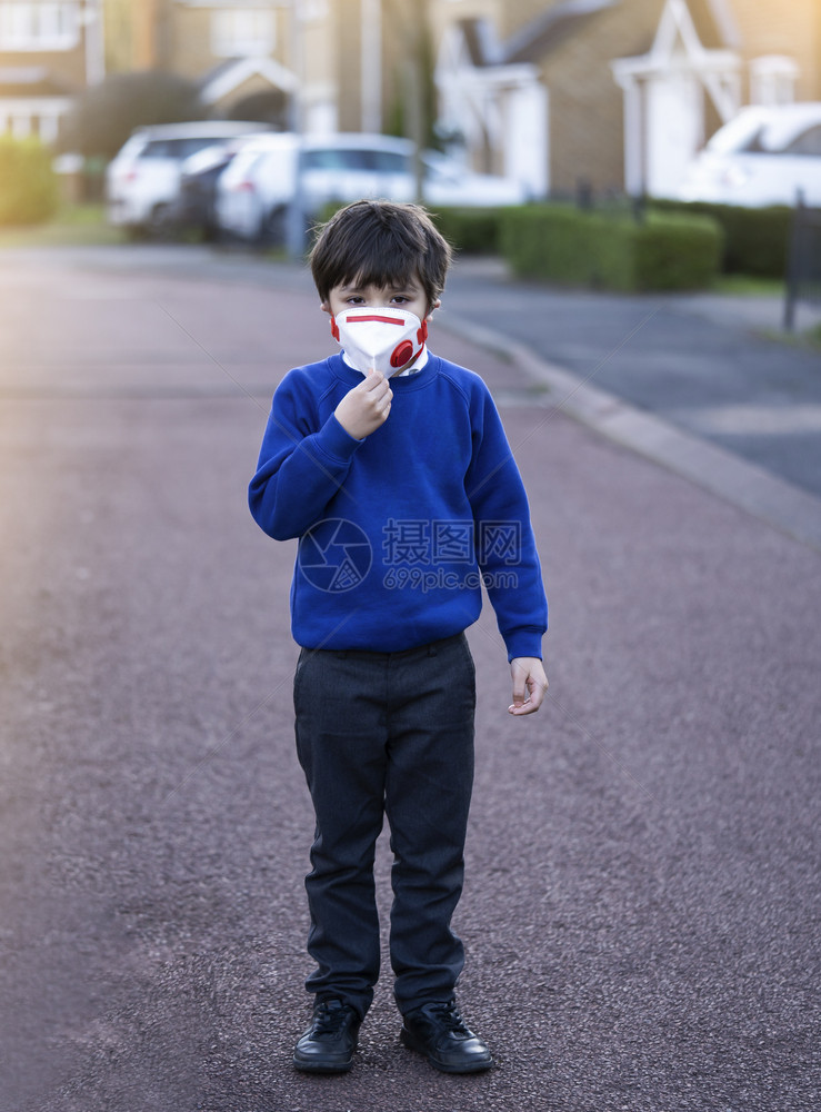 下午身戴防污染或护面罩的婴儿混血亚裔6岁幼童天主教徒步行上学时戴着保护面罩的儿童Corona或Coronava概念组织以及第25图片