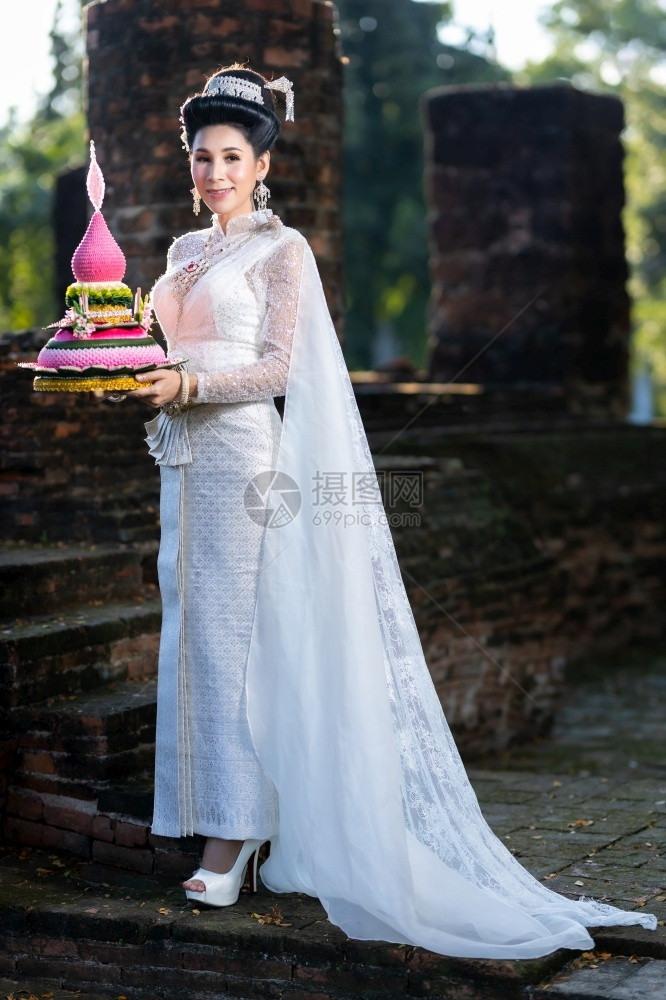 宝塔身着泰国白色传统服装穿着Krathoong和坐在泰国古老城市塔寺门前的Trathong妇女LoyKrathong节Trans图片
