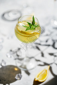 黄色柠檬字体食物现代的柠檬和薄荷的或莫吉托鸡尾酒冷清凉饮料或用冰加的自制豪华轿车在玻璃杯子上一个薄腿A玛格丽塔鸡尾酒一个柠檬片在玻璃里薄的背景