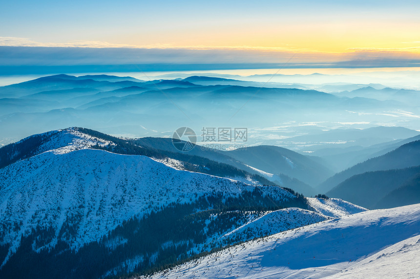 一种霜太阳许多山峰在冬季日落时被烟雾山峰和包围在峡谷的寒冬阳光明媚山峰中度过图片