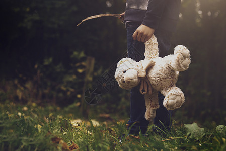 在森林中独自守着Tedddy醒来的TedTed受难儿童失落或无家可归概念的男孩孤单持有其泰德受宠坏儿童失踪或无家可归的概念悲哀科背景图片