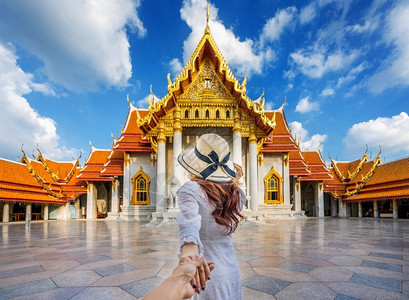 建筑学观光妇女旅游者手牵着rrrrsquos手将他带到泰国曼谷的WatBetchamabophipit或Marble寺庙裙子文化高清图片素材
