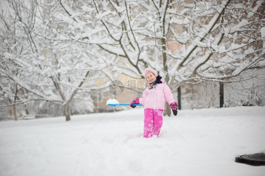 下雪的有趣戏剧孩子在冬天玩雪一个穿着亮色夹克和针织帽的小女孩在冬季公园里为圣诞节捕捉雪花孩子们在白雪覆盖的花园里玩耍和跳跃孩子在图片