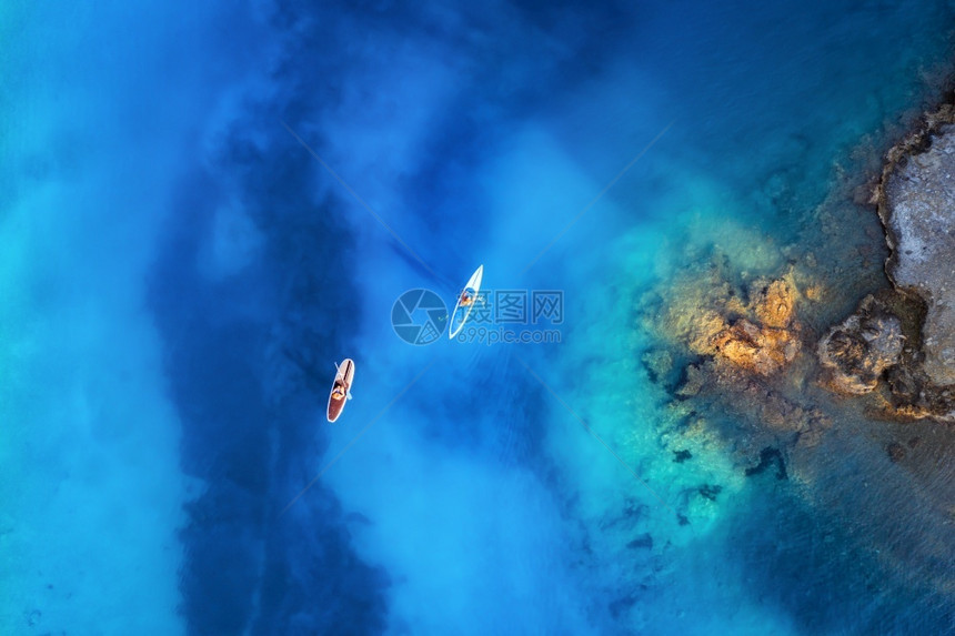 湖火鸡在蓝色海岩石头上漂浮的雪板上人们空中观察夏季在土耳其奥卢代尼兹日落时石块热带风景Kayaks清水除图片