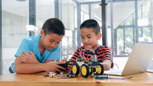 在室内学校手制汽车模型工作电子集中男孩在实验室制造机器人的建筑工程早期开发暗展创新现代技术概念和新颖作坊按钮高清图片素材