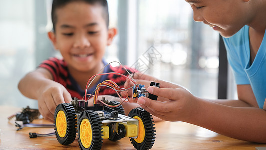 早期的技能手制汽车模型工作电子集中男孩在实验室制造机器人的建筑工程早期开发暗展创新现代技术概念和新颖现代的玩具高清图片素材