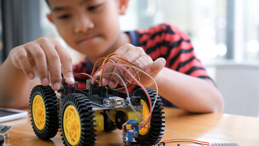手工制作的汽车模型工作电子集中男孩在实验室制造机器人的建筑工程早期开发暗展创新现代技术概念和新颖教育电子的孩子们高清图片素材