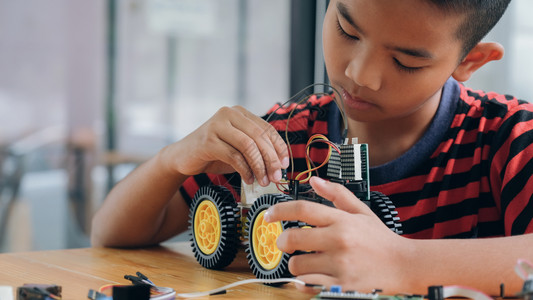 智力创造手制汽车模型工作电子集中男孩在实验室制造机器人的建筑工程早期开发暗展创新现代技术概念和新颖进步建造高清图片素材