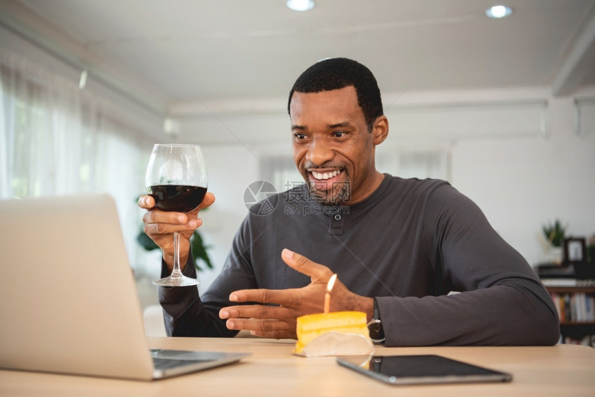 正在做沟通线的快乐笑黑人男子在网上庆祝通过视频电话在笔记本脑上烤红酒在隔离禁闭非裔美国人男子与朋友们一起开会时他和朋友一起过生日图片