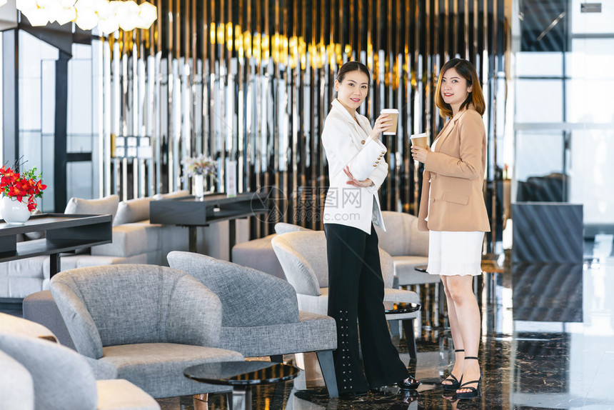 行政人员在现代办公室或合用空间的咖啡休息期有两名亚洲女商人在咖啡休息下班后放松和谈话商业人员伙伴关系概念时发言东盟工作图片