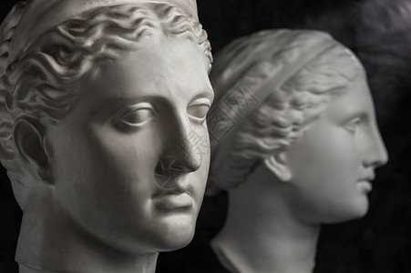 白金星古雕像和戴安娜画家头的白色石膏复制件在黑暗纹理背景上为艺术家制作一张深色原画背景的雕像塑面壁上的白色石膏雕像维纳斯古雕像G背景图片
