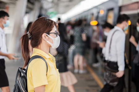在车站佩戴口罩的青年女性游客图片