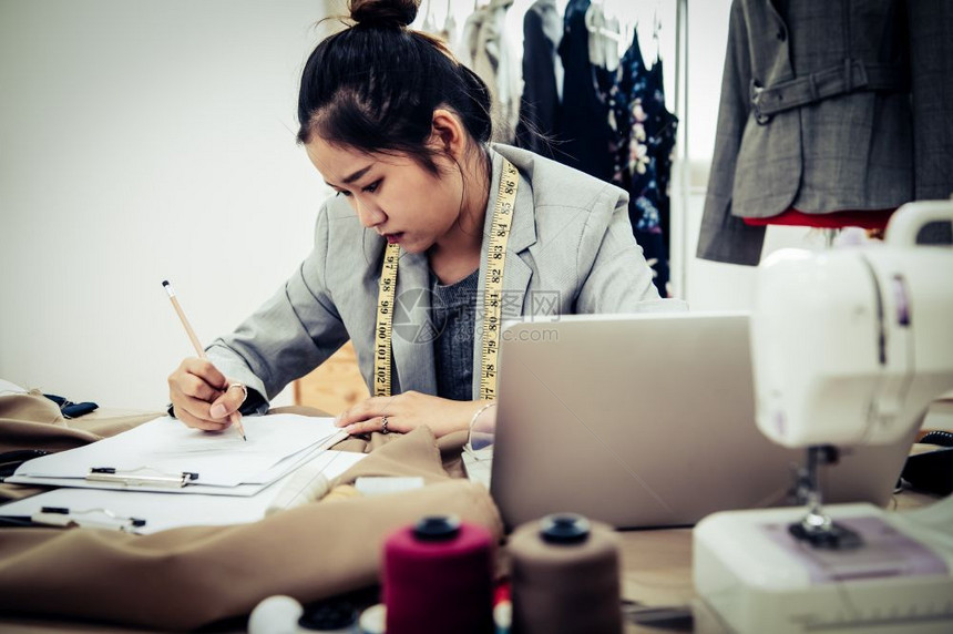 缝纫亚洲商务时装设计师在工作室新系列的服装时完全不知道Dressmamaker头痛和负面思想概念裁缝女强调写作zigzag中风夜图片
