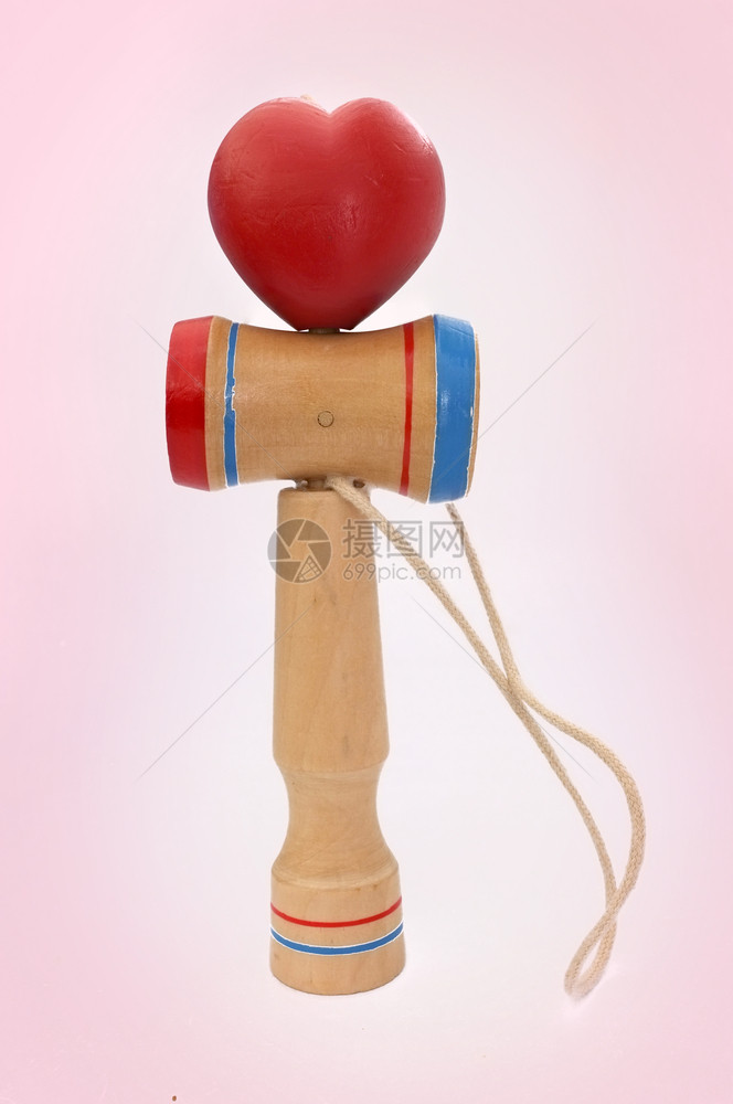 技能杯子火车Kendama是日本传统玩具由一把和颗球组成由串心身滚动的绳子连在一起与粉红背景隔绝概念情人节图片