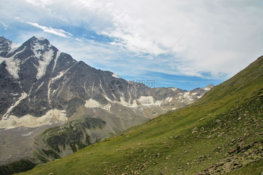 高加索山丘夏季和北高加索地貌位于俄罗斯联邦乌鲁古特山的北高加索风景云层下绿色高山草原晴天冰川石头图片