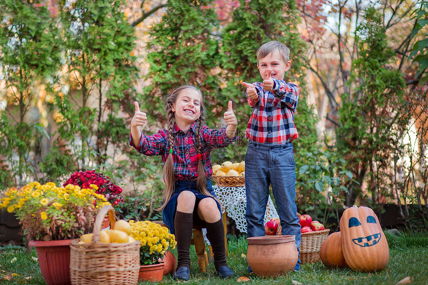 农业兄弟姐妹在秋园玩耍周围是蔬菜水果庆祝秋收兄弟姐妹在秋园玩耍周围是蔬菜水果微笑幸福图片