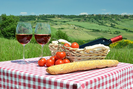 爬坡道红酒面包和番茄在彩布上与意大利的托斯卡纳风景对抗绿色喝图片