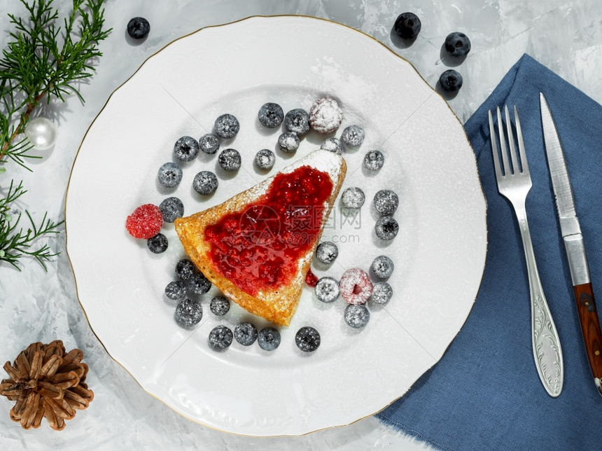 自制煎饼和果酱放在白色盘子上煎饼在环绕煎饼是新鲜的浆果餐桌上装饰着一个Thuja树枝和一个锥形早餐节食物来自上面的Pancake图片