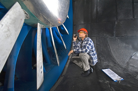 实验室一名工程师身穿一格衬衫检查个大型工业风洞的螺旋体空气动力学电话图片
