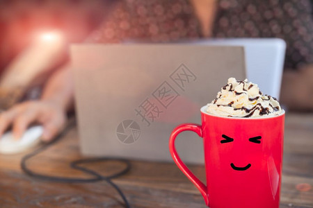 乐享早餐巧克力甜点糖红杯热摩卡咖啡在木桌上面带微笑的脸用笔记本电脑与工人一起作背景