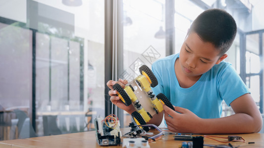 可爱的种族机器人技术手制汽车模型工作电子集中男孩在实验室制造机器人的建筑工程早期开发暗展创新现代技术概念和新颖未来派高清图片素材