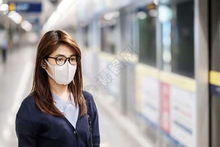 车站戴防护口罩的女性图片