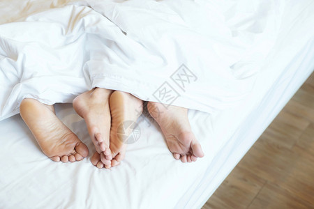 人们皮肤两对情侣并肩睡在一起坐被毛毯白色床单下躺在家中的床上假期概念有浪漫时刻的爱光留下写文字的空间副本女女朋友高清图片素材
