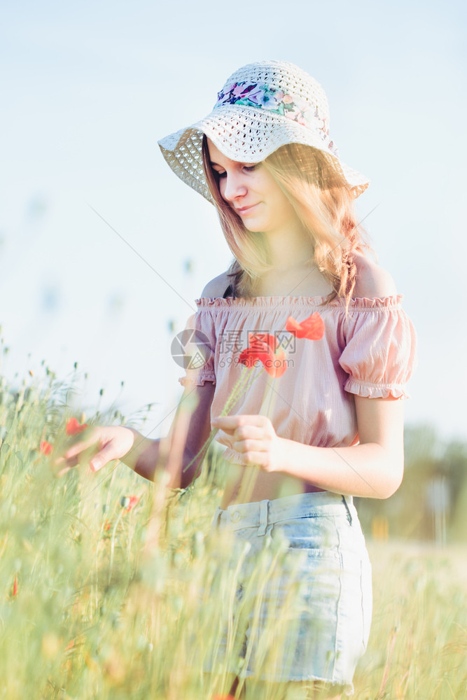 在野花田中美的年轻女孩青少在草原上采春花戴帽子和夏服穿着帽子和夏天衣服与自然相近的时间草地开花绽放图片