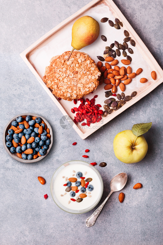 在桌上吃酸果早餐加蓝莓和烤杏仁梅斯里饼干苹果和梨子在桌上吃浅光和健康膳食优质平衡饮板自上而下混合人们营养图片