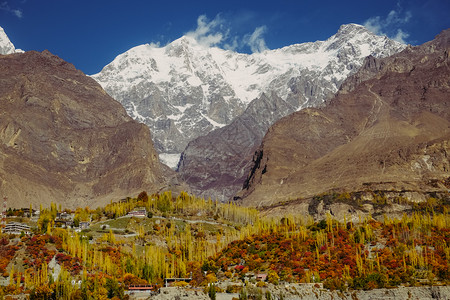 冠豸山风景罕萨巴基斯坦HunzaValleyGilgitBaltistan卡拉科姆山脉的乌塔尔萨峰雪冠对森林中多彩树木的秋天自然景观封背景