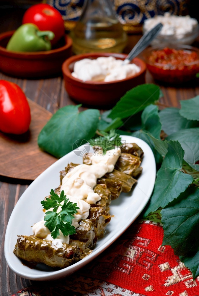 银器异常煮熟的地中海烹饪盘子里的多尔马菜在黑木桌上配有新鲜香肠和酱汁紧闭的多尔马菜传统的肉和葡萄叶高加索人土耳其和希腊烹饪图片