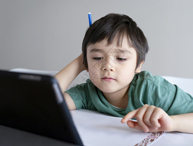 家校互联医疗的为了他孩子呆在家里看关于Tleblet的漫画孩子使用数字平板电脑搜索信息在互联网上寻找家庭作业日校19课锁定社会分化学习在背景