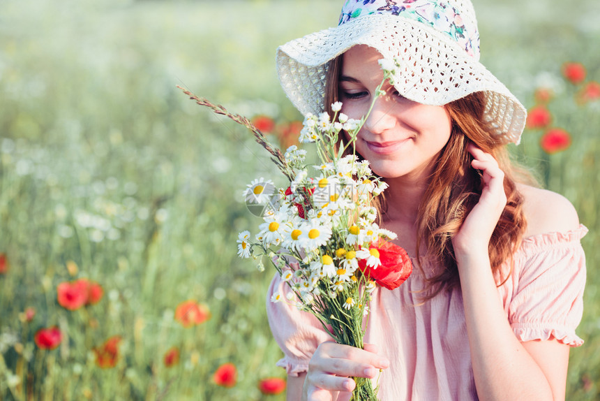 裙子夏天在野花田中的美丽年轻女孩少在草原上采春花拿着束她戴帽子和夏衣与自然相近的时光中度着穿帽子和夏服少女感图片