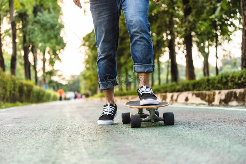 夏天自由泳冲浪板在户外公园的冲浪skate或滑板上闭合亚洲男子腿日出时间与未承认人士跑步运动健康时尚等照片模糊相隔图片